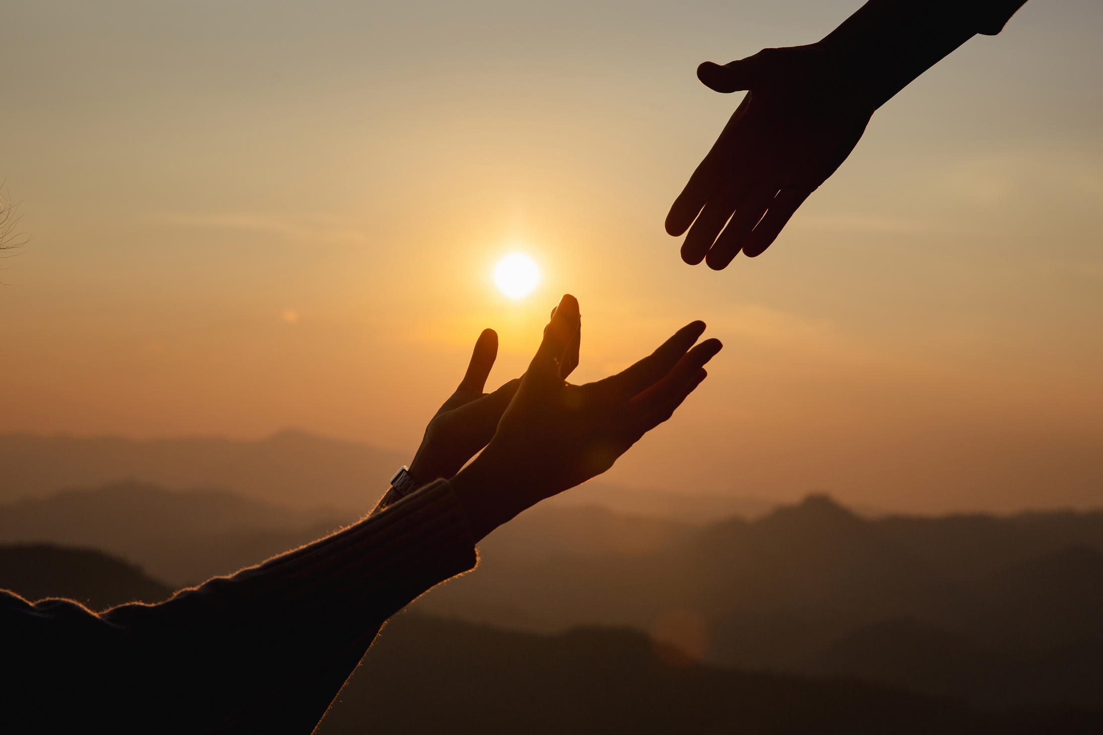 Silhouette of Helping Hands at Sunset